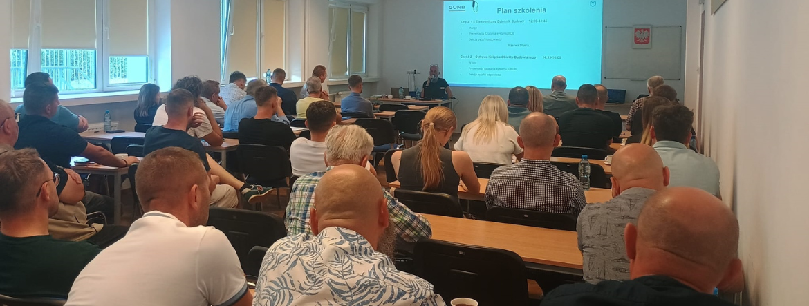 Na zdjęciu sala szkoleniowa – uczestnicy siedzą przy stołach, słuchają prelegenta, na ekranie widoczny jest slajd z planem szkolenia dotyczącym Elektronicznego Dziennika Budowy i Cyfrowej Książki Obiektu Budowlanego.